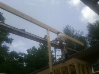 Carpenter setting a ridge beam over a new addition frame — Ice Dam Removal by Roofing Brothers in Hampden