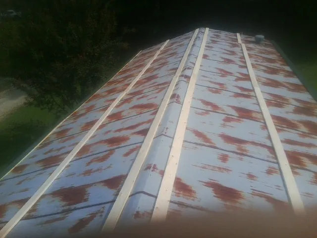 Rusted metal roof panels with new wood purlins before replacement — Storm Damage Roof Repair in Hampden by Roofing Brothers