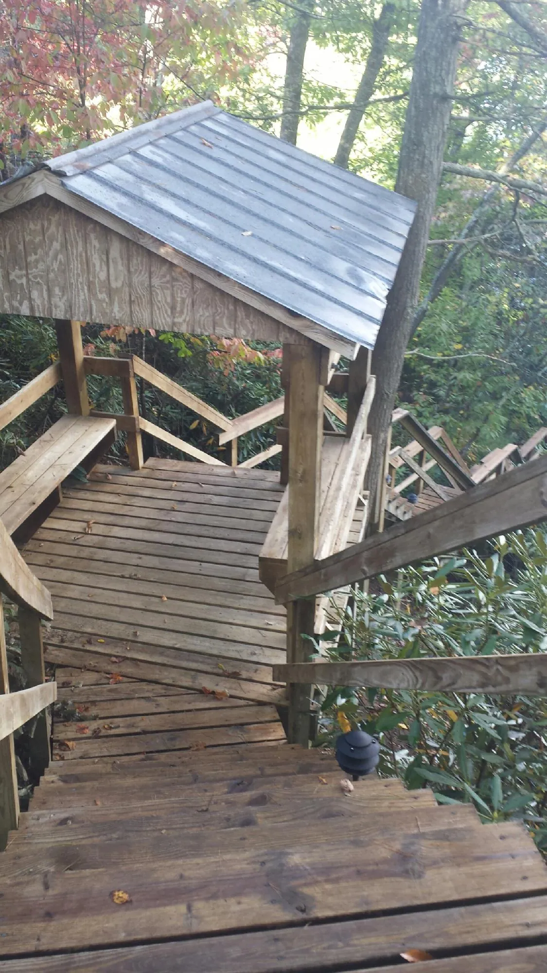 Metal roofed shelter over wooden steps on a wooded walkway — Skylight Repair & Installation work by our crew in Hampden