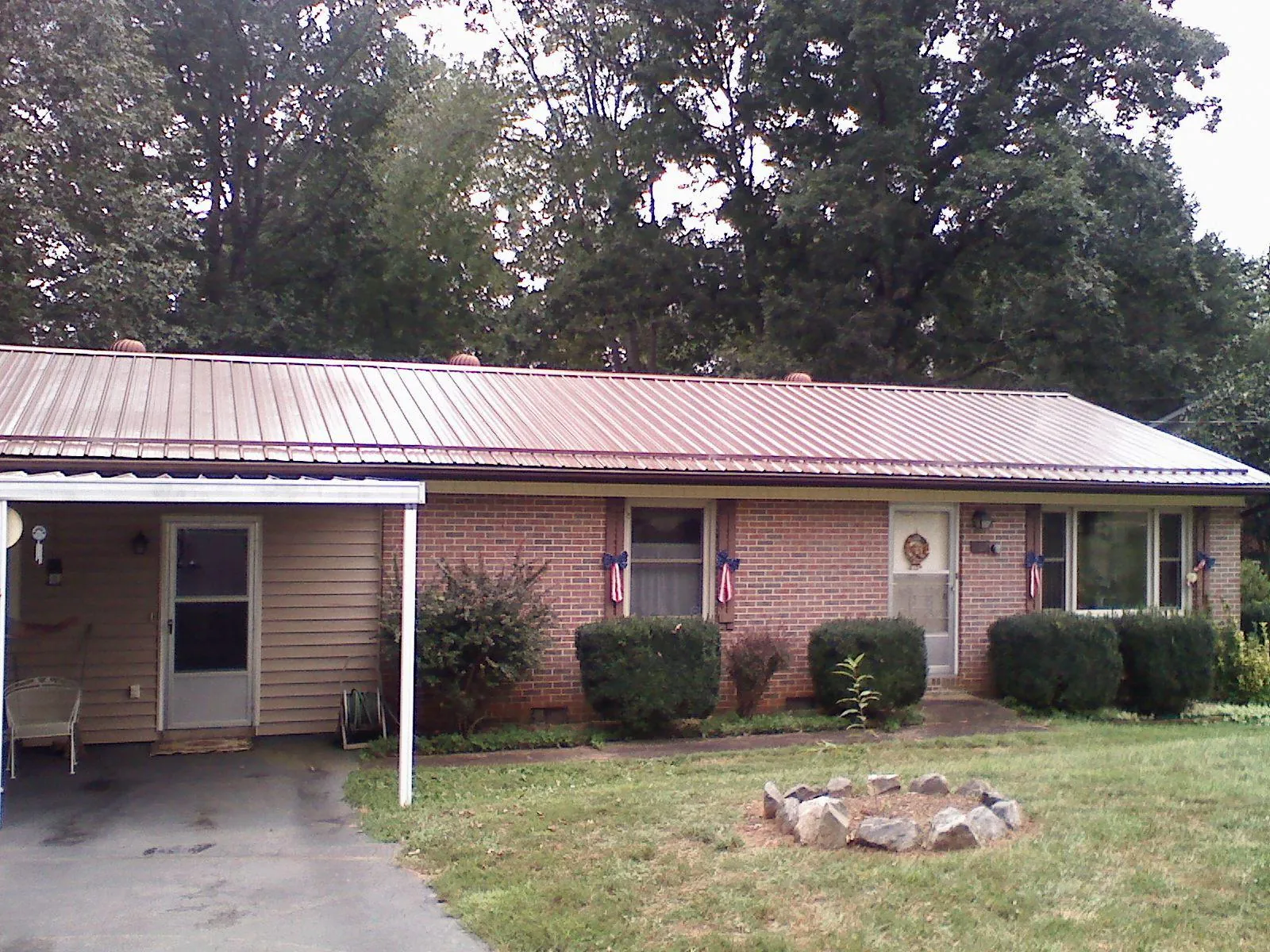 Bronze metal roof and carport on a brick ranch home — Roof Repair work by our crew in Hampden