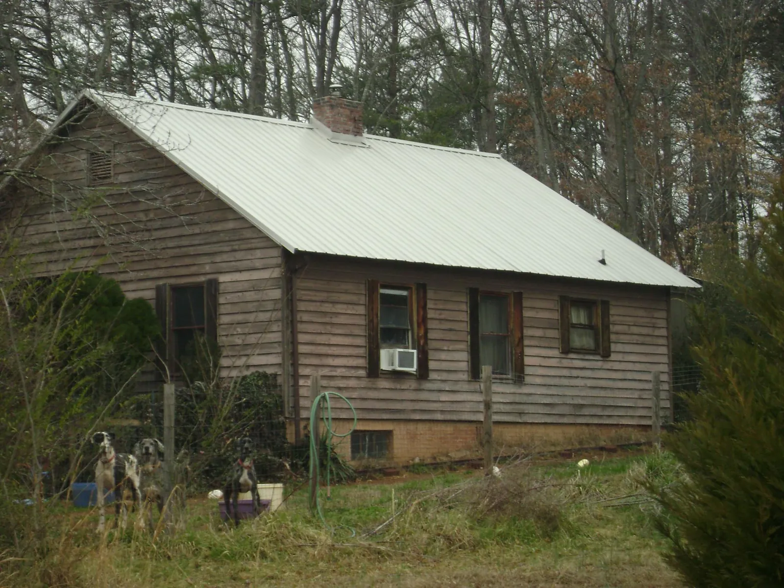 White metal roof on an old wood sided farmhouse, from a Metal Roof Installation job in Hampden